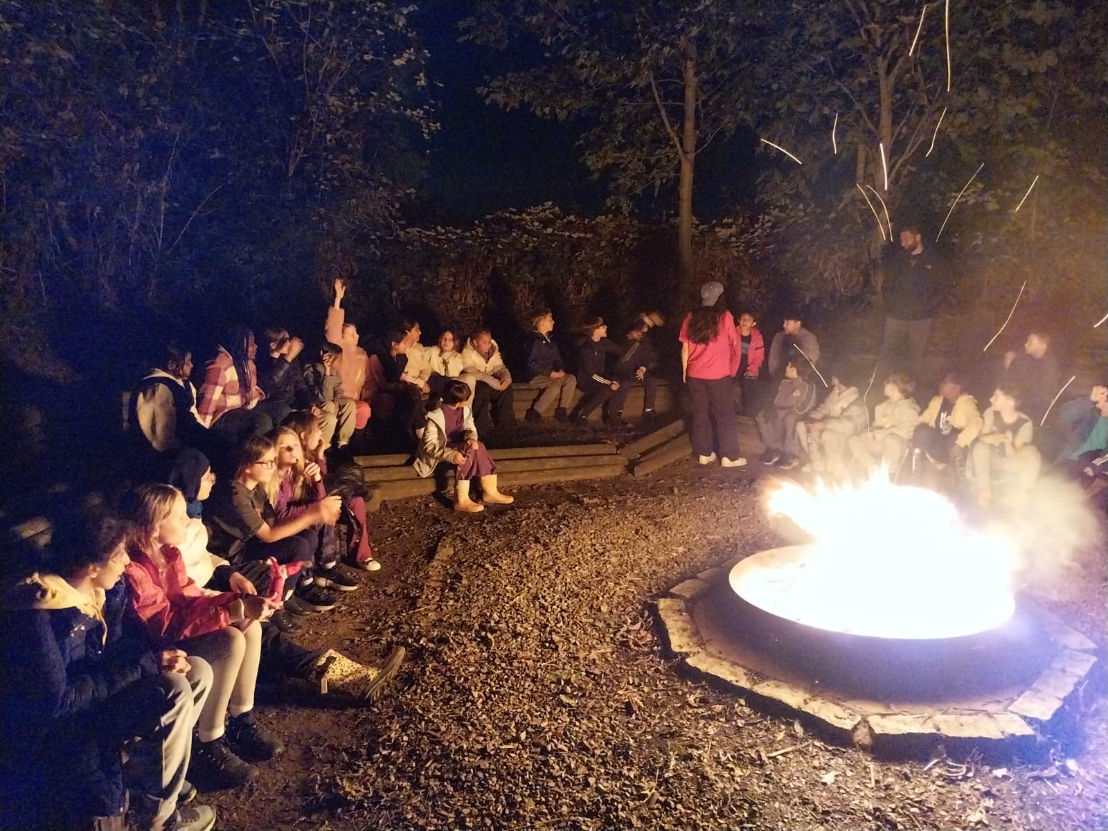 Group of children playing games around a campfire