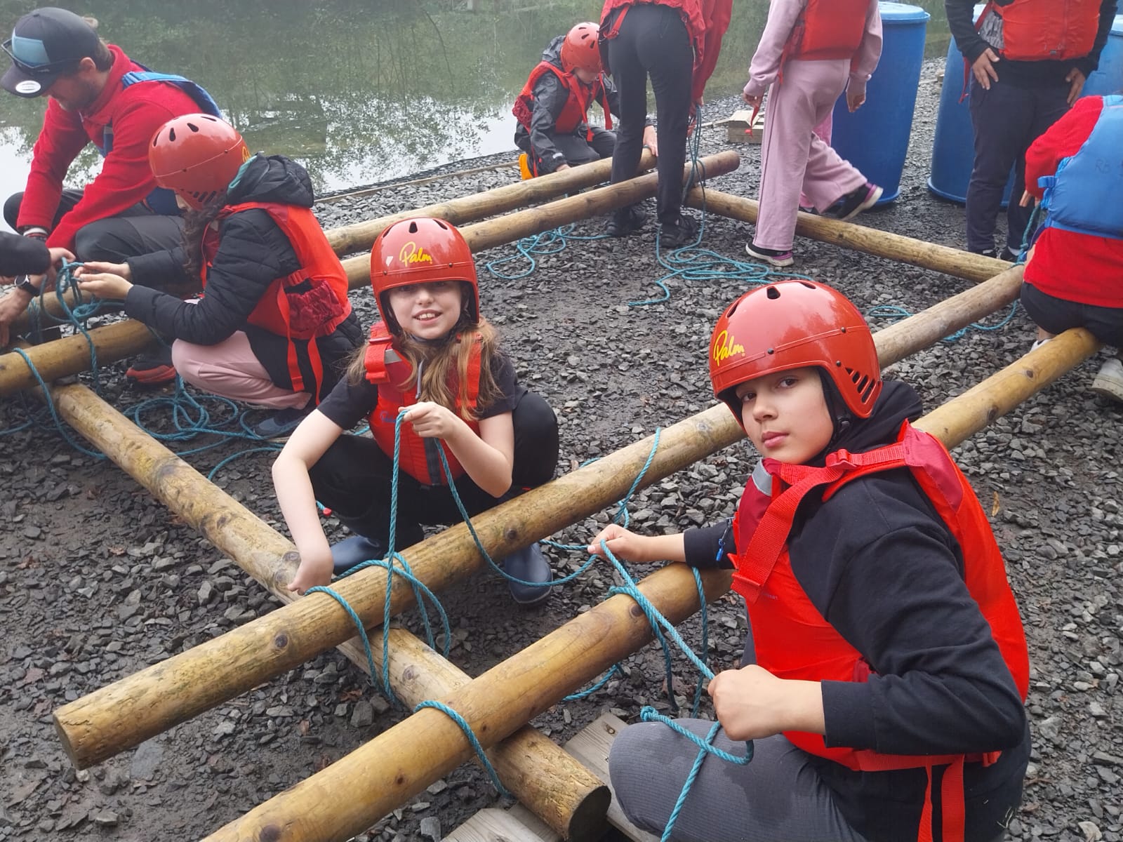Some children tying knots to build a raft