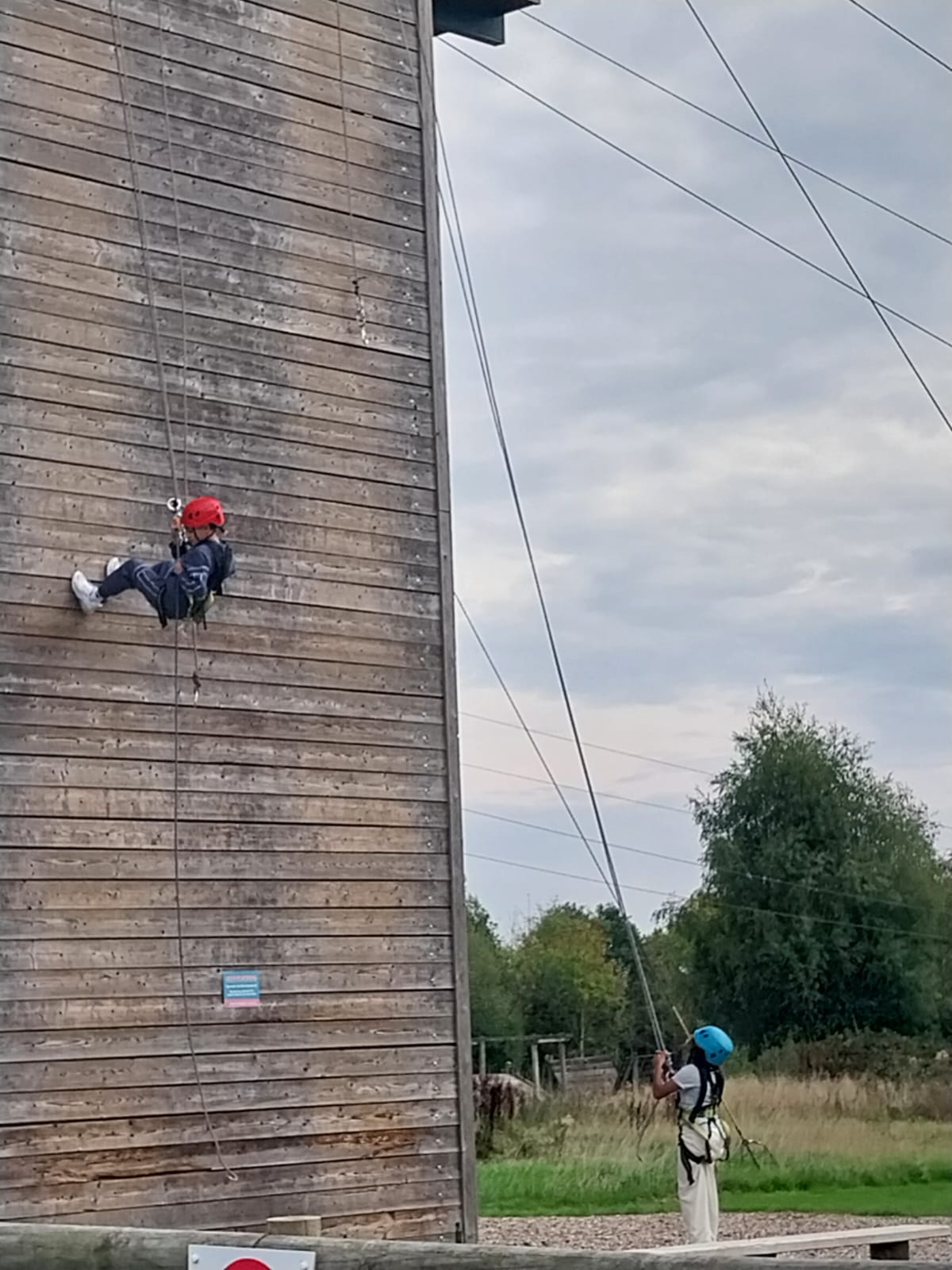 Two children part way down abseiling wall