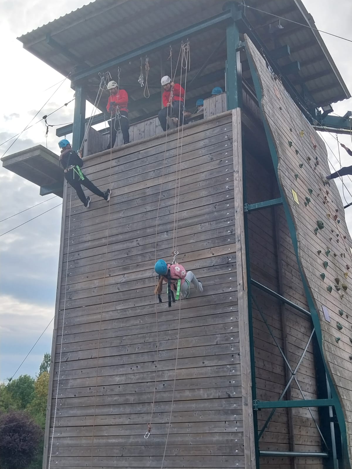Two children part way down abseiling wall