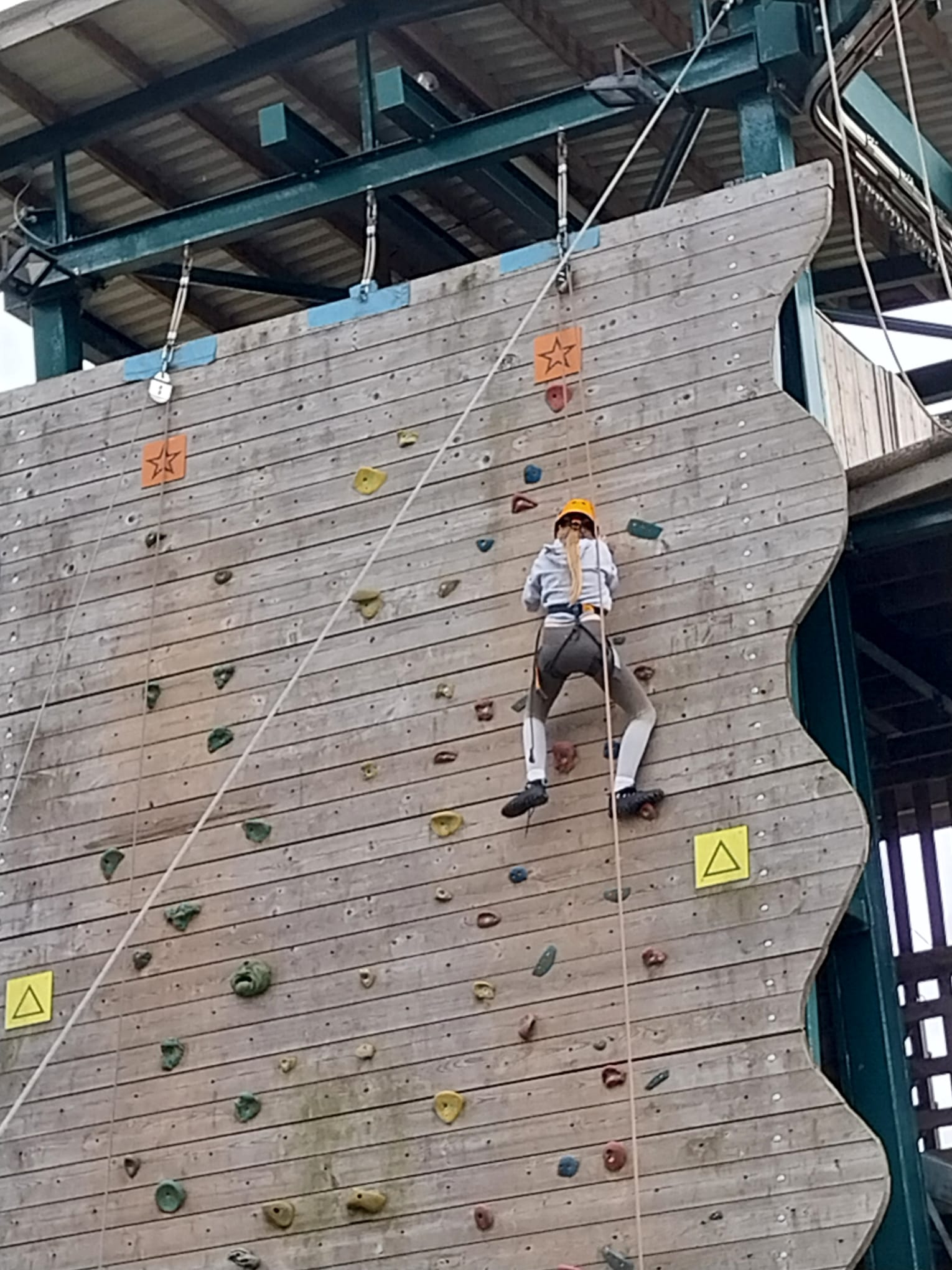 Gril near the top of the climbing wall