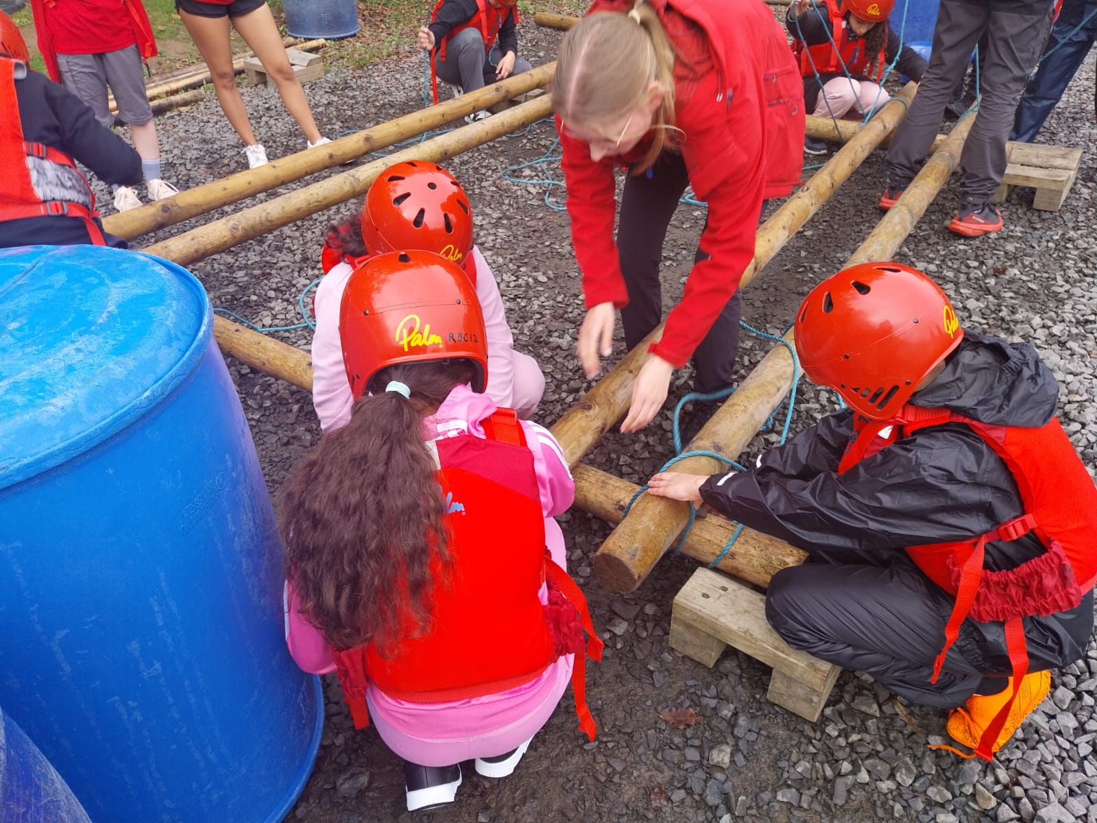 Some children tying knots to build a raft